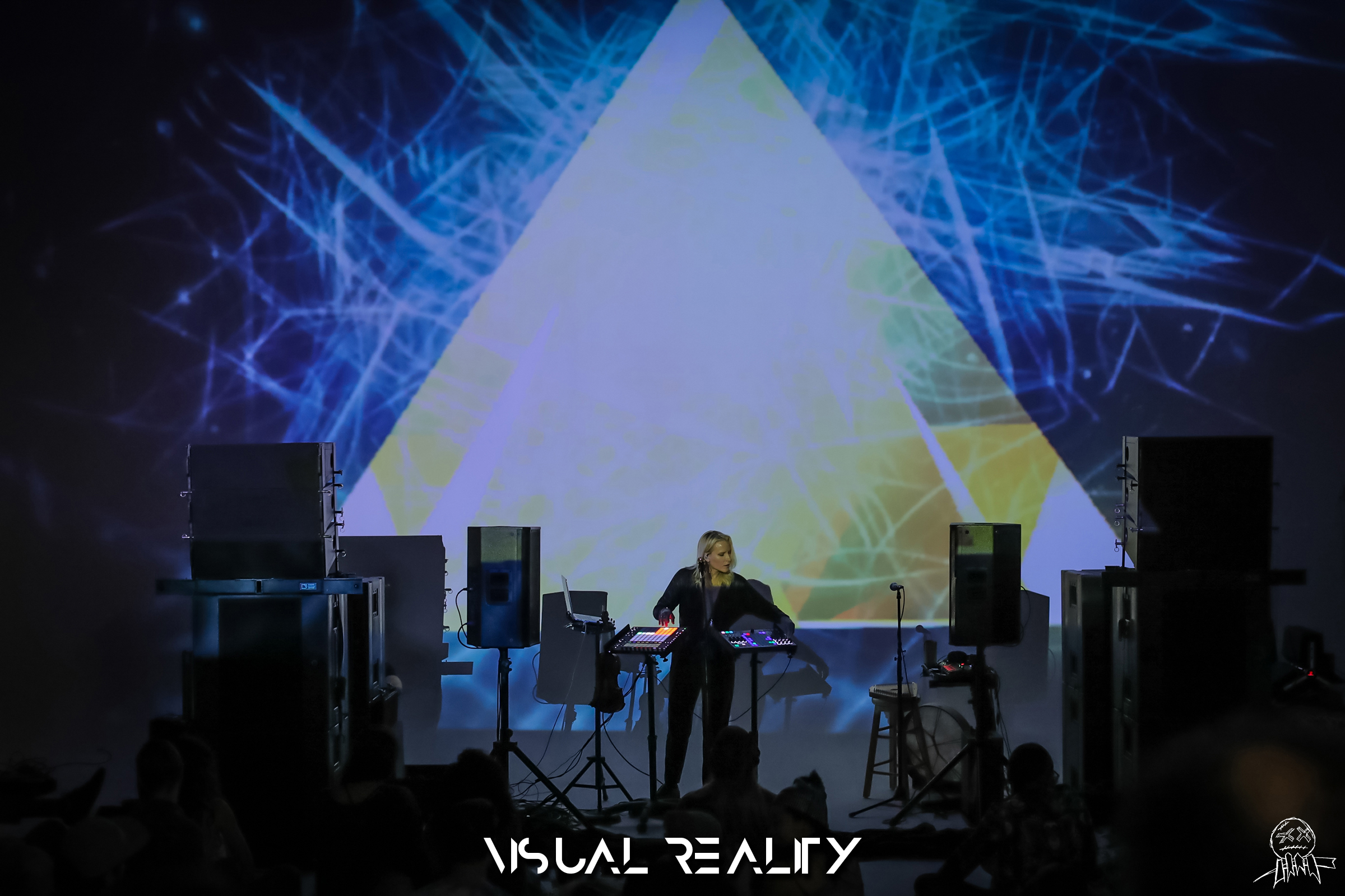 Live performance with yellow triangle projection and spatial audio